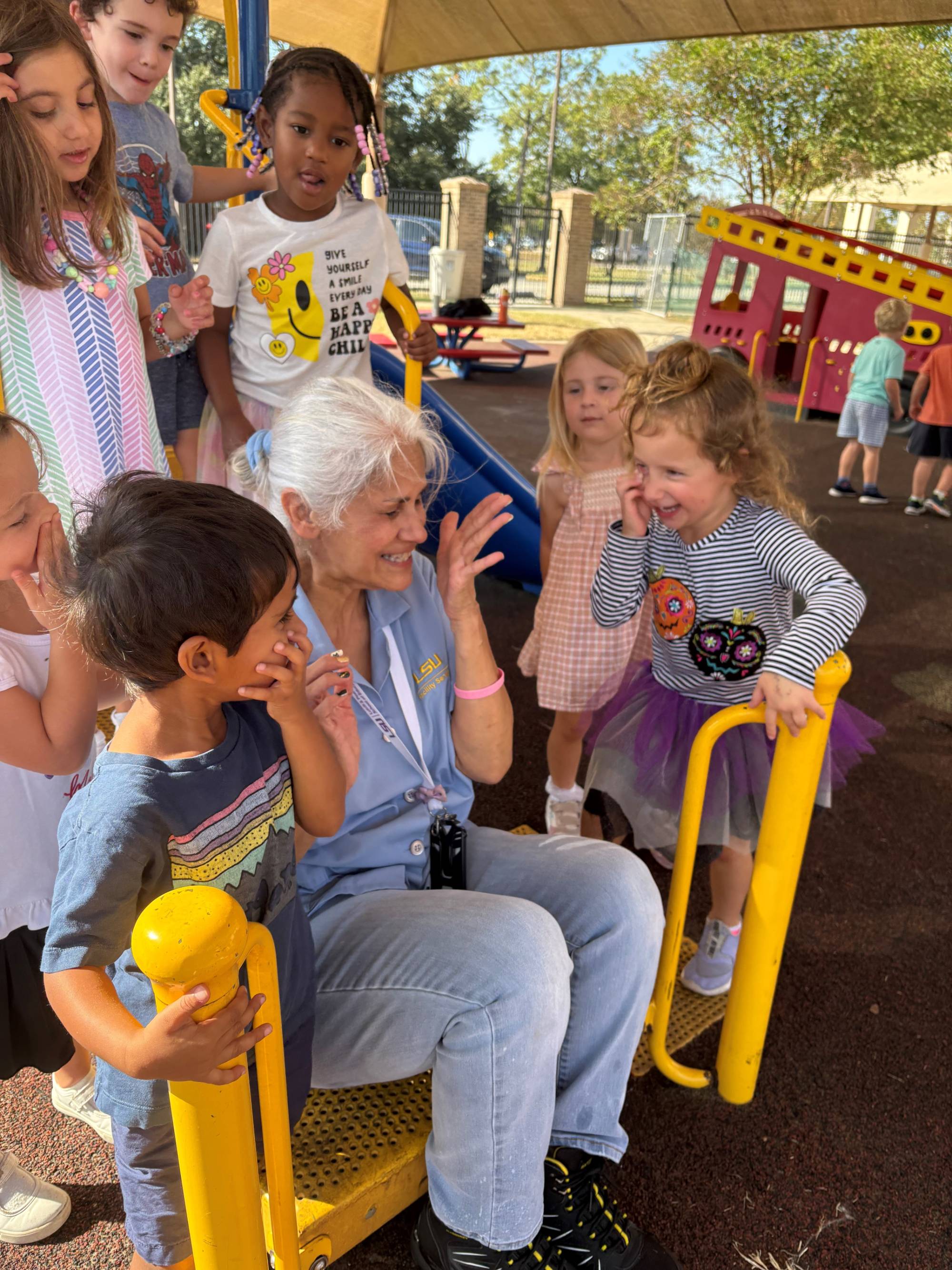 Brenda Finkelstein surrounded by children on a playground